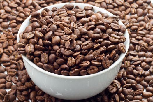Close up of Coffee beans in and around a white bowl