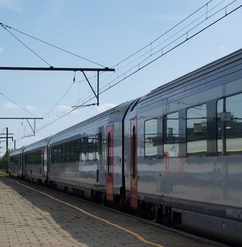 Electric passenger train arriving on an empty station platform