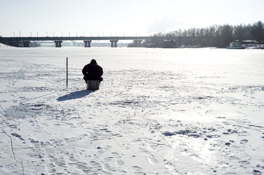 Winter fishing on the river in the sunshine day