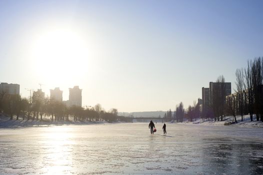 People walking by the Frozen river in the sunshine day