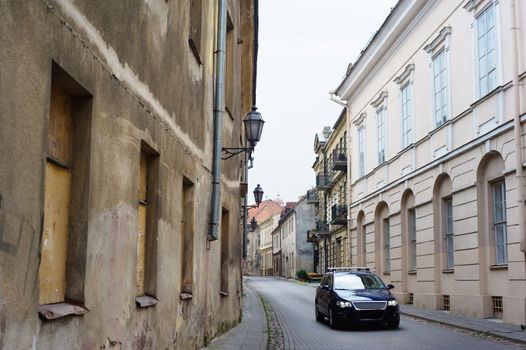 Modern car in narrow paved street of Vilnius old downtown