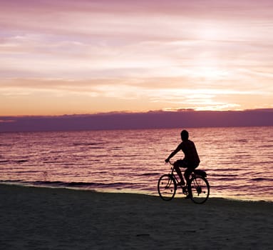 A parson rides by bicycles on the Baltic sea beach