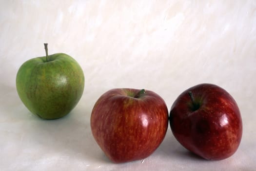 Three apples on painted background