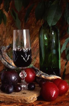 Red wine with fruits. A glass and bottle