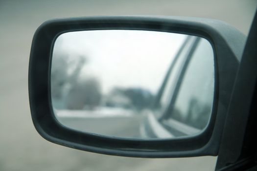 car mirror, mirror in focus, reflection blurred,