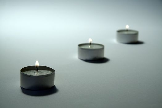 three small candles on white background, distance blur