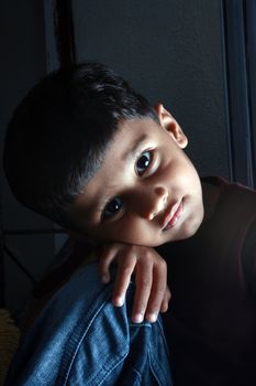 A portrait of an innocent Indian boy in sad mood.