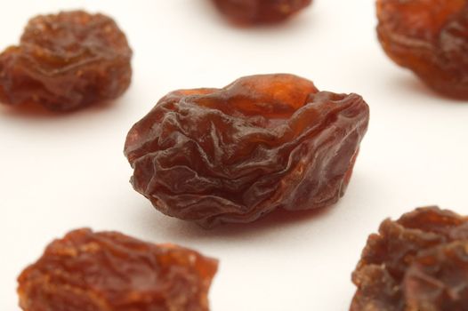 several dried raisins on white background