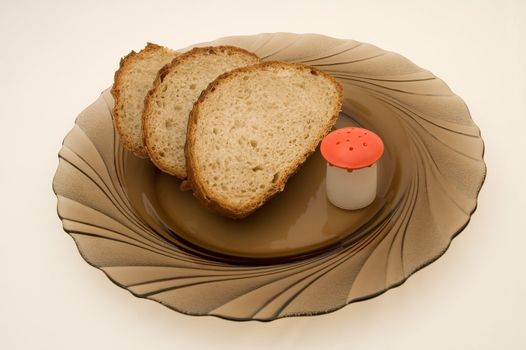 three bread slices and salt shaker on glass plate
