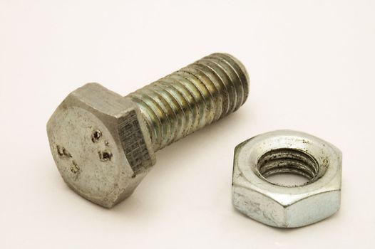 old screw and nut on grey background