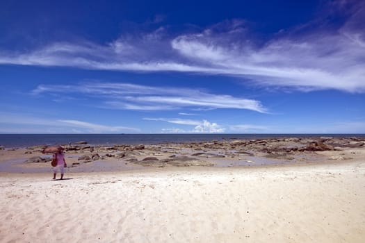 Woman with umbrella on Hua Hin beach