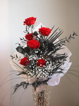 A bouquet of red roses over a desaturated black and white background