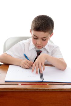 Conscientious young boy writing in a book.   White background.