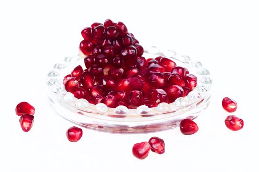 Serving of pomegranate in glass tray isolated on white