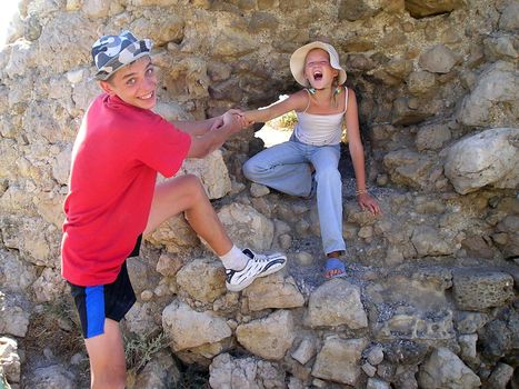 brother and sister or friends frolic among the stones, the historical ruins.