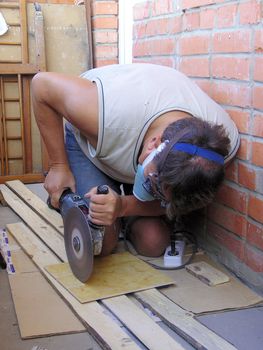 man, jack-of-all-trades, makes renovation, prepared tile to the floor. It saws off the piece of tile by saw.