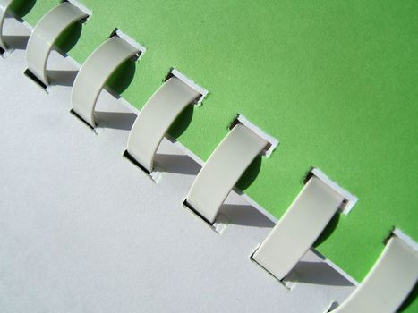 Green and white notebook with white spirals close-up