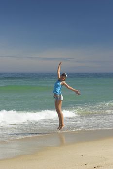 Beautiful woman jumping on a great day of summer on the beach