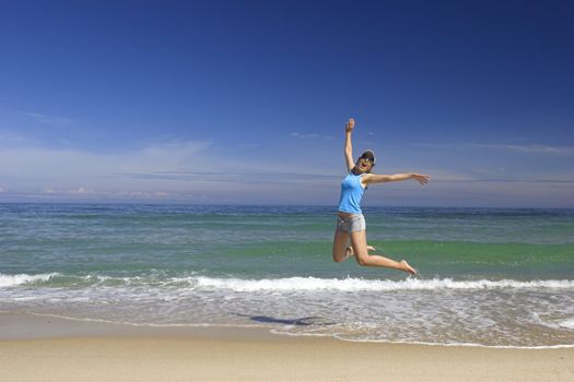 Beautiful young woman jumping on a beautiful beach