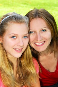 Portrait of smiling mother and daughter in summer park