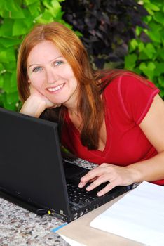 Happy mature woman working on portable computer at home, small business owner