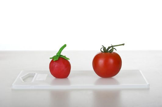 Picture of a healthy tomato and a fake one (great concept about healthy food vs plastic food)