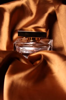 Unique parfume bottle over luxury silk background.