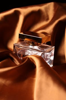 Unique parfume bottle over luxury silk background.