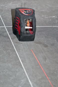 laser level tool with laser beam black on floor