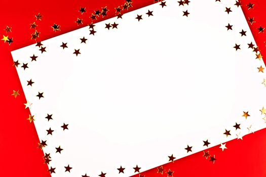 On a red background white greeting card with golden stars.
