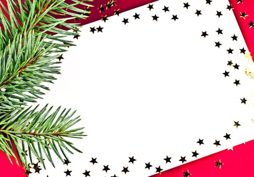On a red background white greeting card with spruce twigs and golden stars.