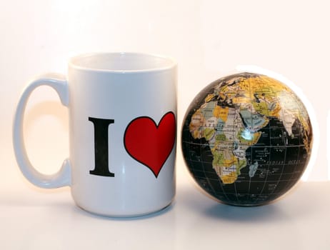 White I Love mug and world globe isolated on white background. World peace, global economy and business market.