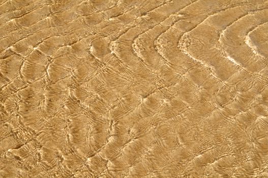 Water ripple on sandy beach for background use.