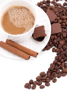 Cup of cappuccino, cinnamon, coffee beans and chocolate