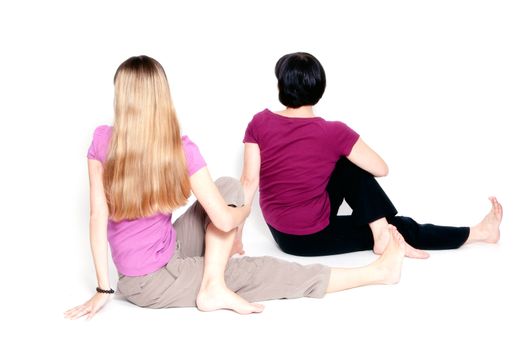 Yoga pose called "sitting half spinal twist" by young and aged woman.