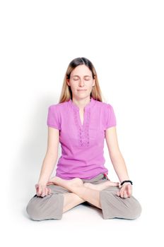 Young woman sitting in lotus seat practicing yoga 