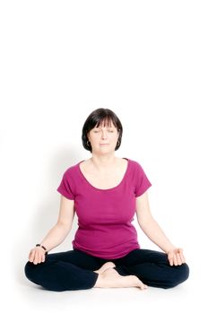 Aged woman sitting in lotus seat practicing yoga.