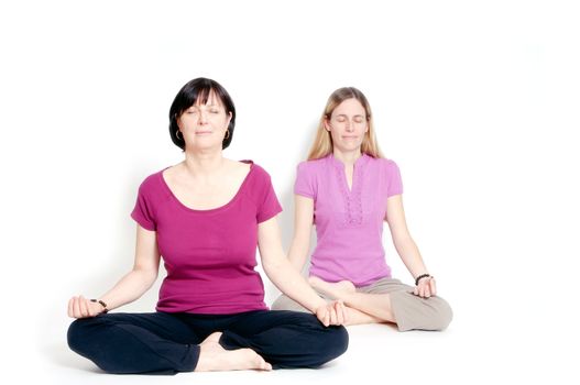 Young and old woman sitting in lotus seat practicing yoga together