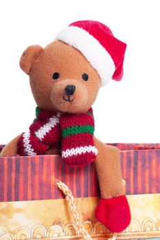 Teddy bear with santa`s hat sitting in a gift box isolated on the white