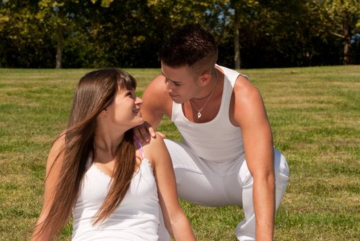 young couple happy sitting on grass white clothes, love relationship