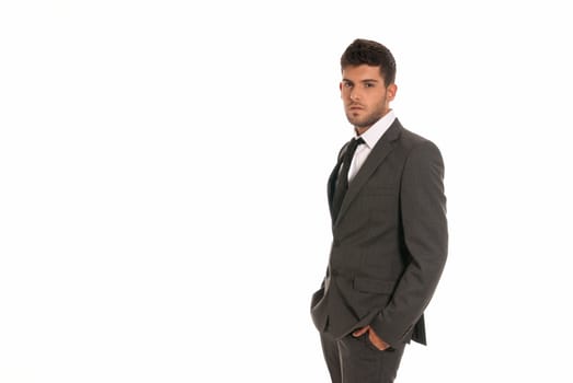 Young businessman with copy-space looking serious hands in pockets isolated on white background