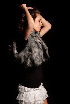 Young beautiful girl dancing on black background