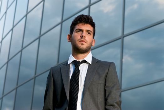 Young businessman looking to good future on modern building background