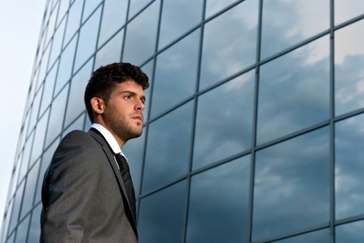 Young businessman looking to good future on modern building background