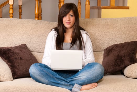 Young woman with laptop portable computer sitting on sofa