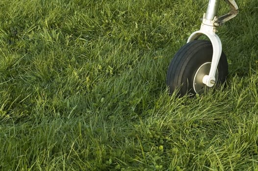 detail of an small airplane wheel on short cutted grass