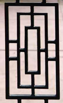 black, near silhouette, of a portion of a deco designed wrought iron gate