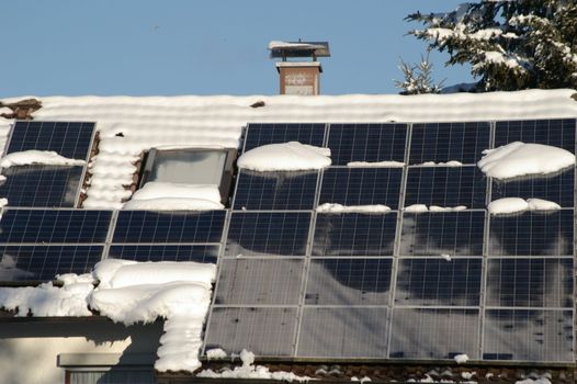 solar cells on a snowy roof in winter