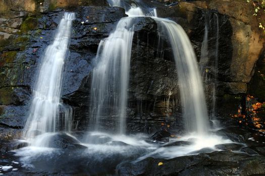 Water falling over mossy and wet rocks
