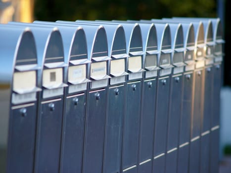 Shiny silver colored postboxes on line, in Finland